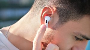 Chàng trai đeo tai nghe Bluetooth không dây hiện đại